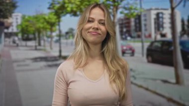 Kırışık kaşlı sarışın kadın, şehir sokağının köşesinde orta parmaklarını sallıyor, başkaldırı isyanının hüsranı..