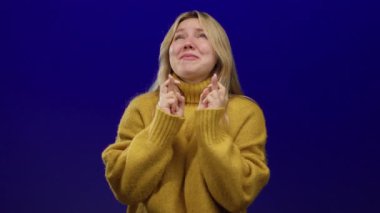 Umut dolu mavi bir arka planda, sarı bir kazakla umut ve iyimserliği ifade eden bir kadın..