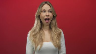 Uzun sarı saçlı ve ağzı açık bir kadın stüdyo resminde şaşkınlık gösteriyor..