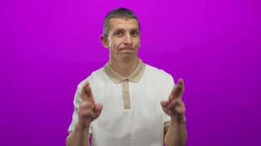 Canlı pembe duvara karşı umut dolu bir jest yapan bir adam izole edilmiş bir ifadeyle beyaz erkek iyimserlik ve beklenti içinde..