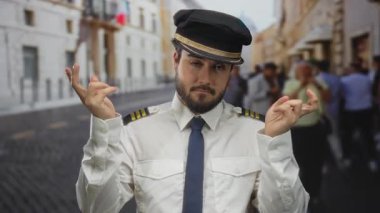 Pilot üniformalı genç adam İtalya 'nın işlek bir caddesinde, kapalı parmaklar ve kapalı gözlerle komik bir ifade sergiliyor.