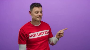 Mor arka planda eli olan, gönüllü gömleği olan ve parmağıyla gülümseyen yakışıklı adam jestleri.