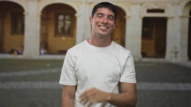 Beyaz tişörtlü adam, eski kasaba sokaklarında taş kemerler ve kaldırımlarla fısıldadığı için el ele tutuşuyor..