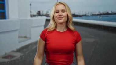 Kırmızı tişörtlü kadın, şehir sokaklarında yüzü bulanık bir şekilde, canlı bir ortamda, şehir yaşamını gözler önüne seriyor..