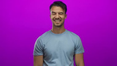 İzole edilmiş pembe bir arka planda güvenle gülümseyen genç adam çeşitli temalar için canlı, neşeli ve modern bir ifade sergiliyor..