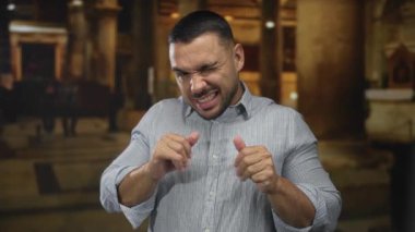 Yumruklarını sıkan adam, boks duruşunu gösteren sütunlar ve sıralar arasında iç yapı inşa ederken kaşlarını kaldırdı ve buruşturdu..