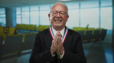 Havaalanında sıkıca sarılmış gülümseyerek gülümseyen kıdemli bir adam minnettarlık ve başarı duygusu taşıyor..