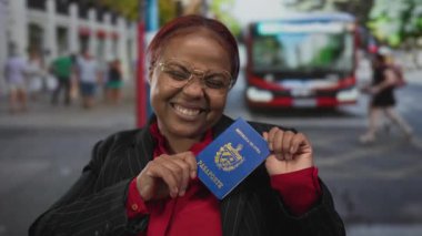 Kalabalık bir caddede elinde Küba pasaportu olan Afro-Amerikalı kadın gülümseyerek seyahat özgürlüğü gururu.