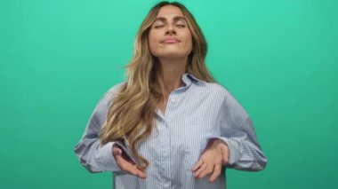 Sarışın kadın stüdyoda el hareketlerini gösteriyor..