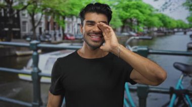 Erkekler, bisiklet ve ağaçlarla dolu bir caddenin ağzının etrafında el ele tutuşur. Heyecan ve iletişim..