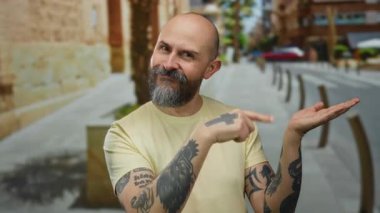 Dövmeleri olan kel bir adam şehir sokaklarında kendine güvenen, dövmelerini gösteren ve sıradan bir ortamda gülümseyen bir adam..