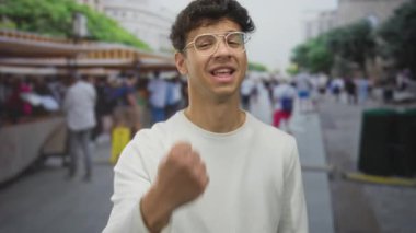 Genç İspanyol adam, pazar yerinde gergin bir ifadeyle yumruğunu sıktı; öfke hüsranı.