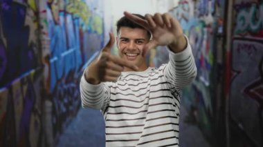 Genç İspanyol asıllı bir adam, şehrin canlı grafiti kaplı bir caddesinde, açık hava ortamında neşe ve yaratıcılık saçıyor..