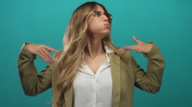 İş kadını, turkuaz bir stüdyoda özel dikim spor ceket ayarlıyor; kendine güven, zarafet soğukkanlılığını dengeliyor.