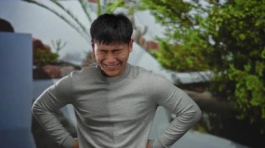 Parkta genç bir adam, doğal yeşil bir geçmişe karşı bir fikri varmış gibi güler ve bir ilham ve mutluluk anı yakalar..