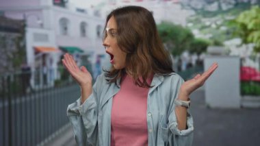 Kadın şehir sokaklarında sürpriz bir ifade sergilerken, şehir arka planında gençlik heyecanını vurgulayarak tepki veriyor.