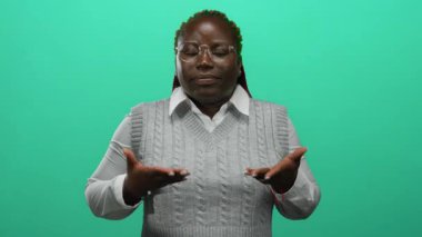 Beyaz gömlek ve gözlük takan, sakinliği ve odaklanmayı temsil eden, kapalı gözler ve anlamlı el hareketleriyle, kapalı bir duvar arkasında meditasyon yapan bir kadın..