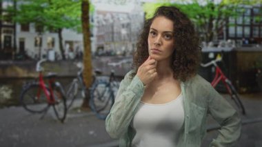 Amsterdam 'da beyaz kolsuz bluz ve katıksız gömlek giyen, eli kanlı bir kadın, düşünceli bir kararlılık..