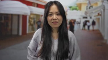 Şehir merkezindeki kalabalık caddede Çinli kadın dikkatli bir el hareketi yapıyor..