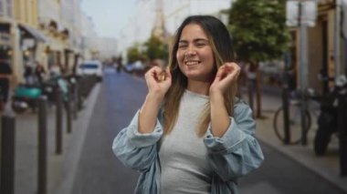 Meşgul şehir caddesinde el ele tutuşan genç bir kadın scooterlarla ve cesurlarla dolu bir sokakta gülüyor..