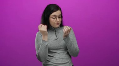 Kahverengi saçlı bir kadın, canlı pembe bir arka plana karşı güven içinde, çeşitli oyuncu ve anlamlı pozlarda gri bir kazak giyerek duygularını ve merakını ifade ediyor..