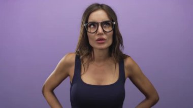 İspanyol kadın mor stüdyoda yuvarlak gözlüklü ve siyah kollu tişörtlü, meraklı..