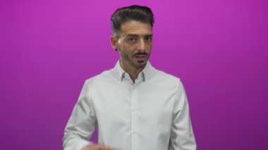 Stüdyoda mor arka planda el ele tutuşan İspanyol asıllı genç adam dikkatle merakla bekliyor..