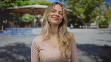 Uçan sarı saçlı bir kadın güneş ışığı altında orta parmağını hareket ettirir. İsyan isyanının öfkesi azimlidir..