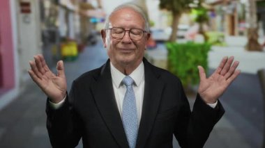 Takım elbiseli kıdemli işadamı, sokakta ellerini kaldırdı. Kendine güveni ve başarısı var..