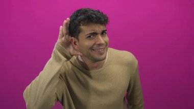 Genç Hispanik testleri renkli arkaplan meraklısı aleyhinde duyarken adam fotoşopta kulak misafiri oluyor..