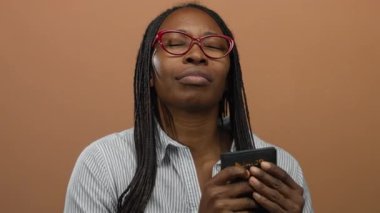 Meksika pasaportu taşıyan, kahverengi arka planda gözleri kapalı kırmızı gözlüklü seyahat ve kimlik kavramlarını gösteren bir kadın..