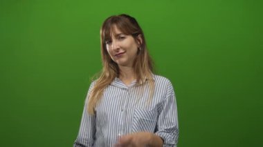 Stüdyoda, yeşil perde arkası ve çizgili gömleği olan, genç Kafkas modeli şüphecilikle göz göze gelen bir kadın var..