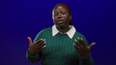 Yeşil kazaklı kadın, mavi arka planda hayranları var. Sıcak ortamda rahatlıyor..