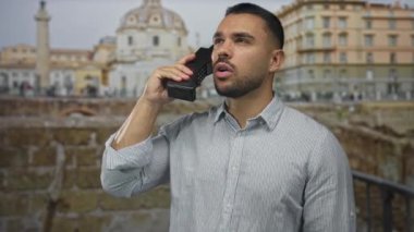 Eski mermer bina harabelerinde, sıcak güneş ışığı altında siyah cep telefonunu kulağına kadar tutan adam nostalji..