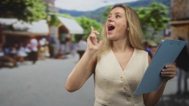 İşlek caddede parmak gösteren ve elinde pano tutan bir kadın ve arkasında insanlar bulanıklaşıyor..