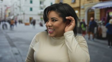 Canlı bir şehir caddesinde gülen ve dinleyen bir kadın, bulanık şehir manzarası ile çevrili, neşeli bir konuşma sırasında neşe ve bağlılık saçan.