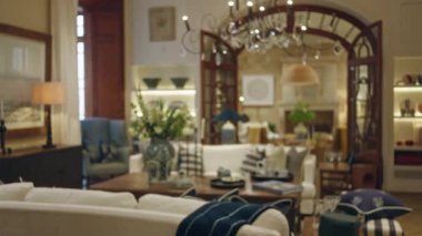 Zarif dekorlu bulanık oturma odası, pelüş koltuklar ve yumuşak bokeh ışıklandırması rahat bir ev atmosferi yaratır..