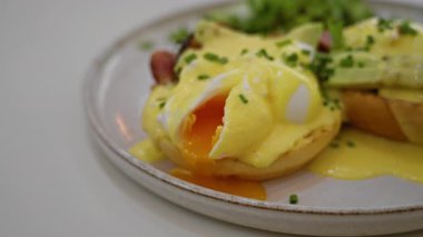 Yumurta ve yumurta sarısı, seramik tabakta frenk soğanıyla süslenmiş şık bir restoranda servis edilir..