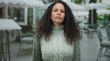 İspanyol kadın restoranın terasında el kol hareketleri yapıyor. Açık havada hayal kırıklığını dile getiriyor. Orta parmakları havada, duygusal bir anı yakalıyor..