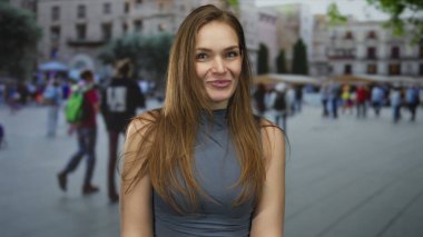 Bulanık kalabalığın ortasında kalabalık bir caddede gülen ağzı açık beyaz bir kadın..