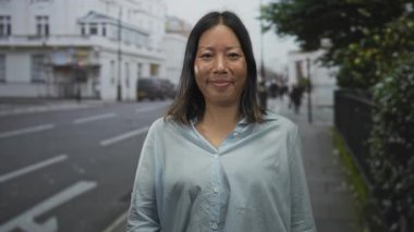 Kadın hem işaret parmaklarını işaret ediyor hem de şehir sokaklarında görülebilen avuç içlerini işaret ediyor; güven teşviki.