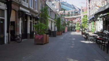 Amsterdam 'daki şehir caddesinde bulanık, bokeh efektli bir sahne, Hollanda' daki canlı şehir hayatının özünü yansıtıyor..