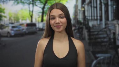 Beyaz bir genç kız, çıplak omuzlu ve eli başının üstünde, kalabalık bir şehir caddesinde. Sürpriz bir farkındalık..