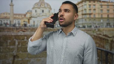 Eski mermer bina harabelerinde, sıcak güneş ışığı altında siyah cep telefonunu kulağına kadar tutan adam nostalji..