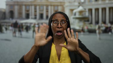 Vatikan 'ın St. Peter Meydanı' nda ikonik mimari ve hareketli turistlerle kültür ve seyahat deneyimlerini vurgulayan kadın şaşkınlığını dile getirdi.