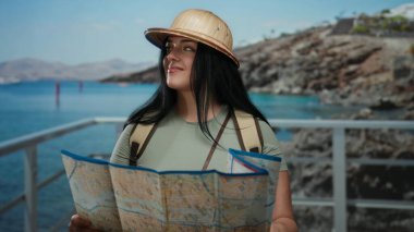 Kadın turist haritası açık deniz manzaralı açık hava haritası şapka takıyor ve macera dolu seyahat titreşimleri oluşturuyor..