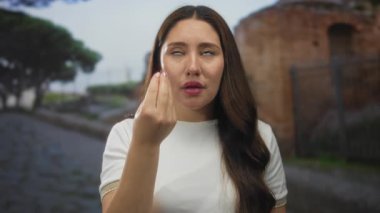 Tuğla binanın önündeki güneş ışığıyla aydınlatılmış sokakta gözleri kapalı ve görünür yüzlü genç İspanyol kadın. Huzur..