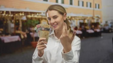 Şehir merkezindeki sokak pazarında elinde Kanada dolarları tutan kadın dükkanlar dolanıyor, hareketli bir şehir ticaret sahnesi yakalıyor..