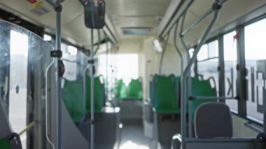 Yeşil koltuklu boş bir otobüsün içi ve parlak ışık dağılmış nakliye aracının içinde sakin bir atmosfer yaratıyor.