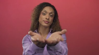 Bir stüdyo ortamında bakarken avuçlarını uzatan ve nazikçe gülümseyen kadın; nezaket dinginliğine hoş geldin..